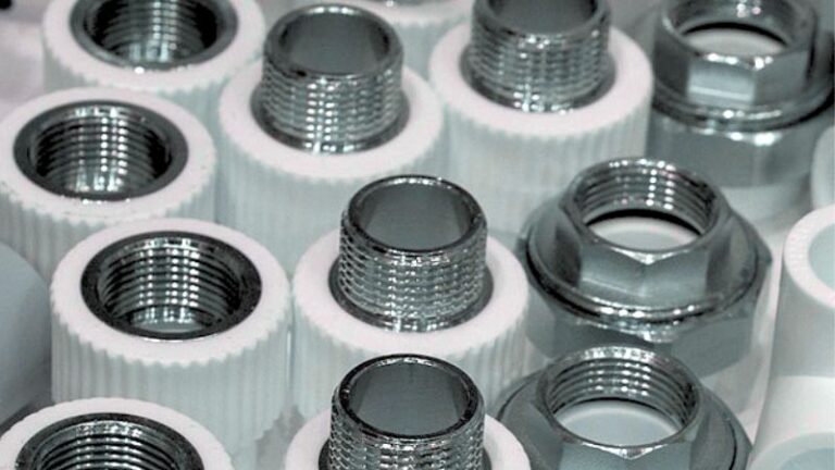 Gros plan de raccords de tuyaux métalliques filetés avec colliers en plastique blanc.