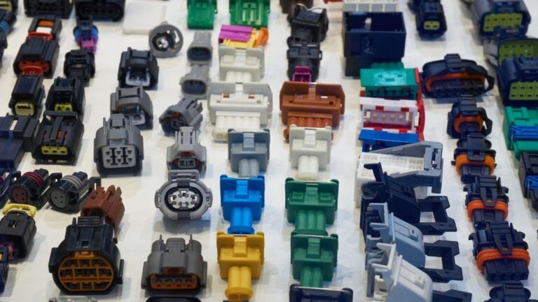 Assorted plastic injection molded electronic connectors and parts used in electronics production, showcasing precision molding techniques.