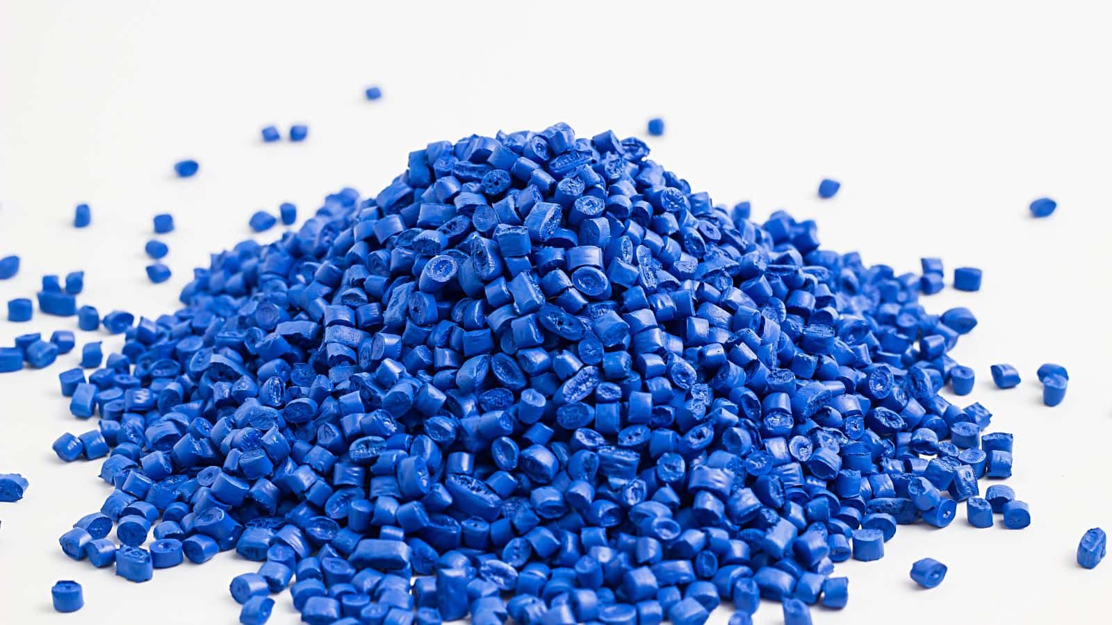 Blue plastic pellets used in injection molding for electronic components manufacturing.