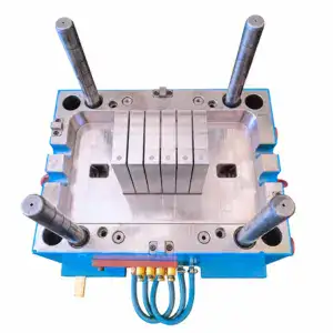 Injection mold for plastic battery box with multiple cylindrical pins and cooling channels, used in manufacturing battery enclosures.
